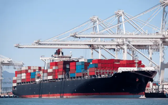 Container ship at the quay under cranes