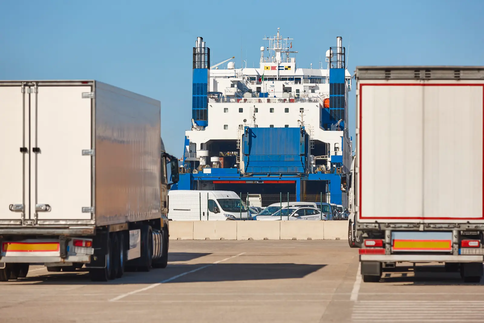 Semi-trailers at a ferry port, in front of a Ro-Ro ship ready for boarding