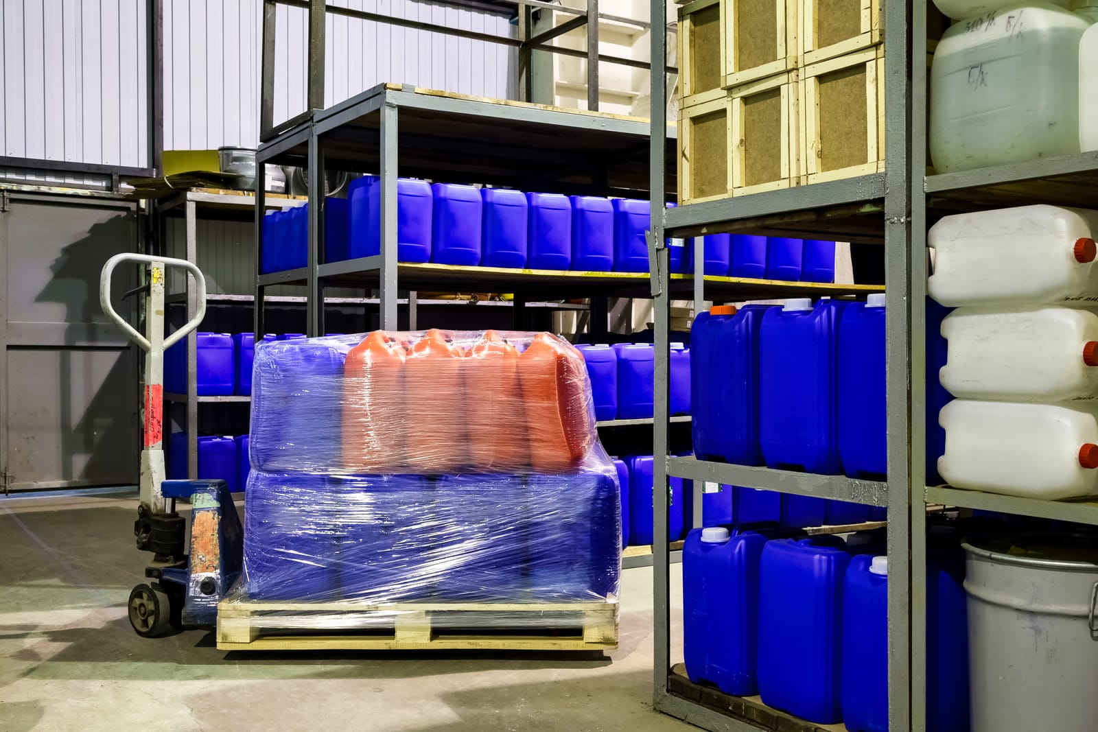 Blue and white plastic containers stacked on shelves in a warehouse